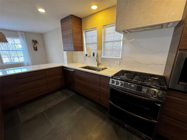 a kitchen with a sink a large window and wooden floor
