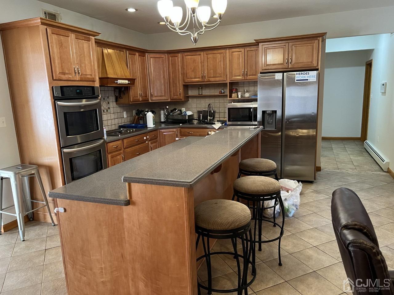 60 Utica Road Edison, NJ 08820 - Photo 12 of 38 a kitchen with stainless steel appliances granite countertop a stove a refrigerator a sink dishwasher a dining table and chairs with wooden floor