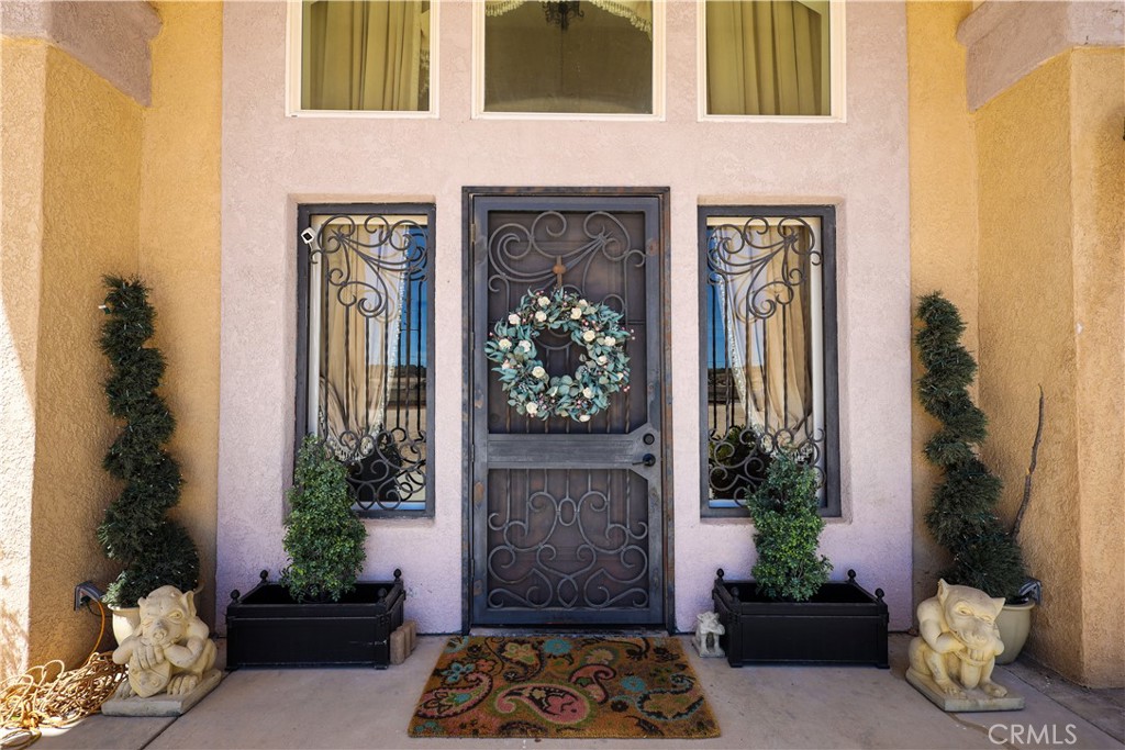 10180 Deep Creek Road Apple Valley, CA 92308 - Photo 1 of 1 a building with potted plants in front of door