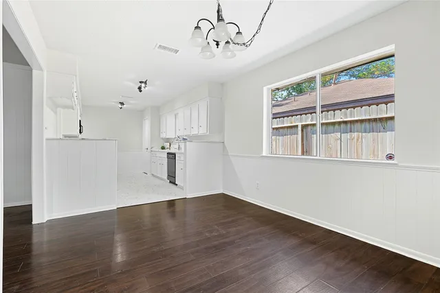 a view of a kitchen with wooden floor and a window