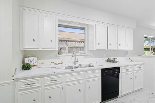 a kitchen with white cabinets and white appliances