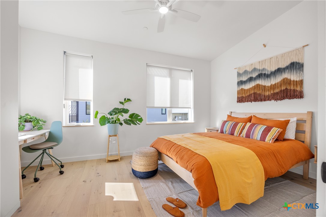 1909 Dutton Drive, Unit B San Marcos, TX 78666 - Photo 13 of 25 a bedroom with a bed and a chandelier