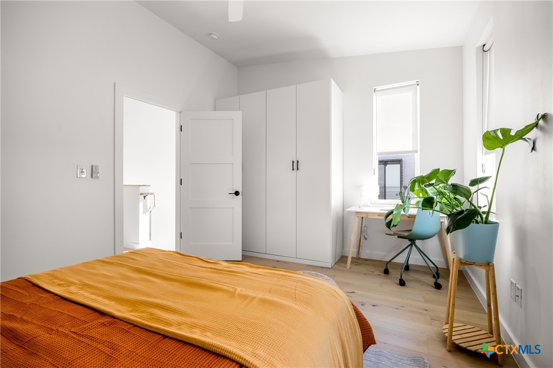 1909 Dutton Drive, Unit B San Marcos, TX 78666 - Photo 14 of 25 a bedroom with a bed potted plant and a dresser