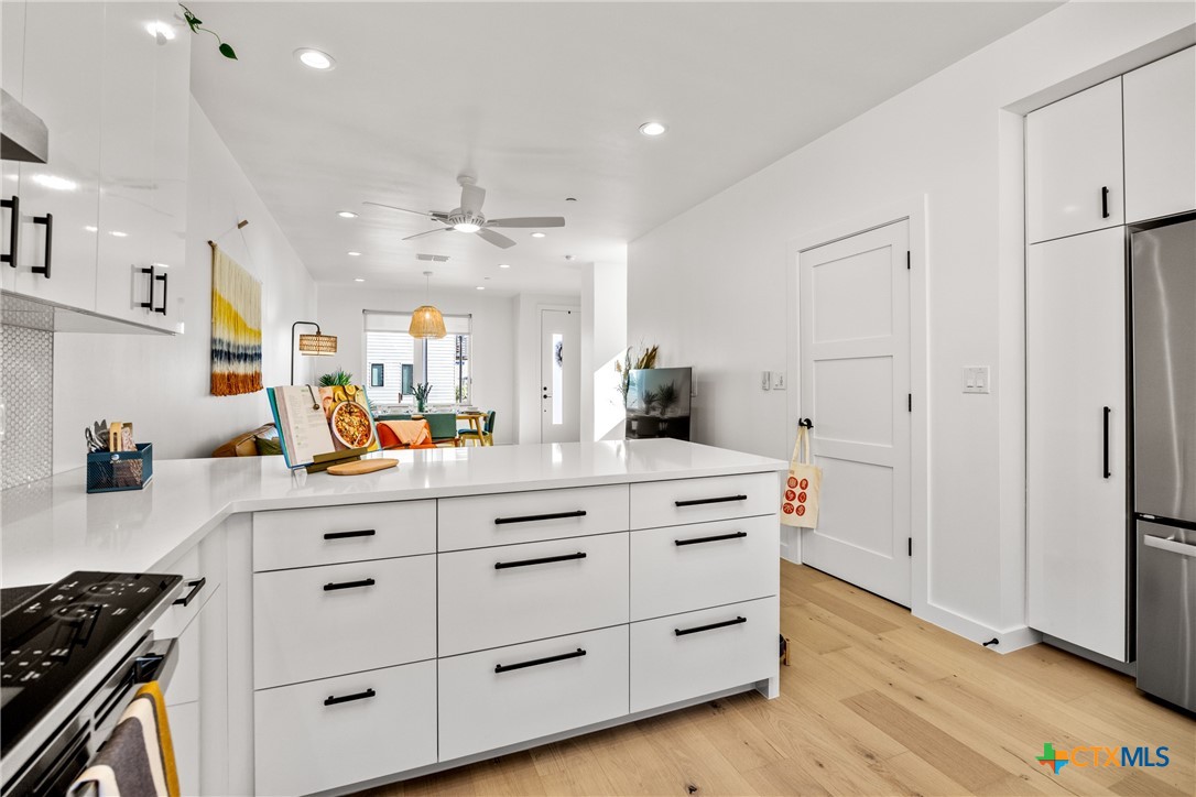 1909 Dutton Drive, Unit B San Marcos, TX 78666 - Photo 7 of 25 a kitchen with a white stove cabinets and wooden floor