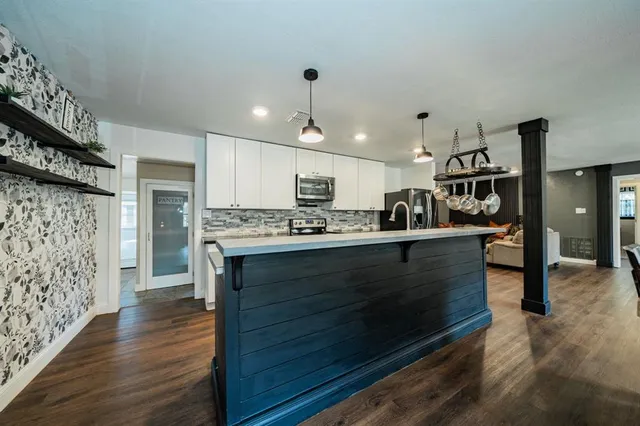 a kitchen with stainless steel appliances granite countertop a stove refrigerator and cabinets