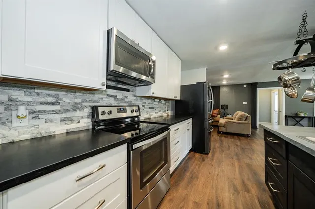 a kitchen with granite countertop stainless steel appliances and wooden cabinets