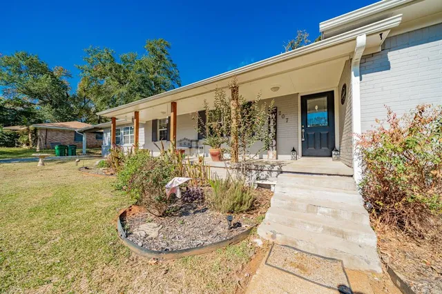 a view of a house with backyard porch and sitting area