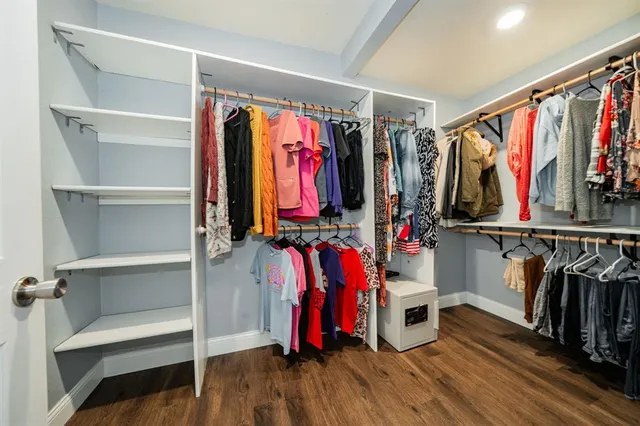 a view of walk in closet with clothes and shoes