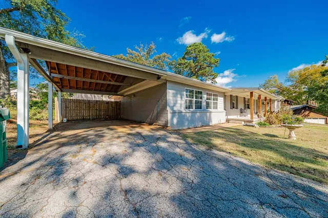 a view of a house with a big yard and large trees