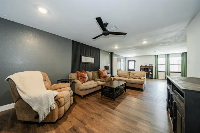 a living room with furniture and a wooden floor