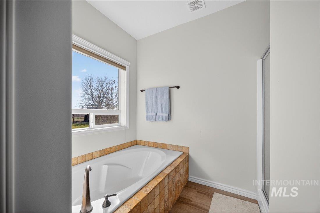 5408 Cassia Road New Plymouth, ID 83655 - Photo 17 of 49 Full bathroom with a garden tub, light wood-type flooring, and a shower stall