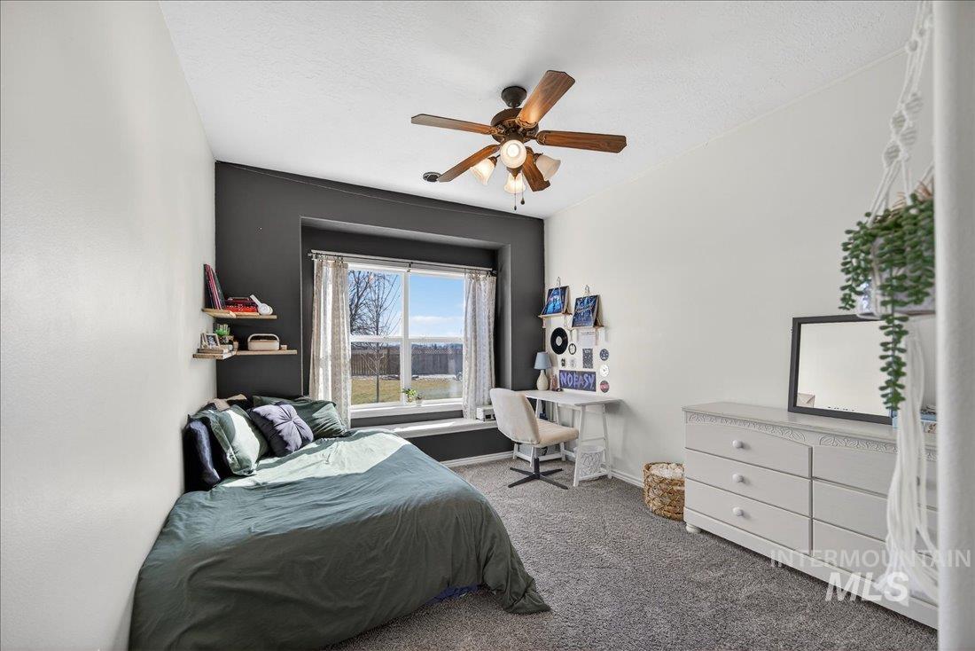 5408 Cassia Road New Plymouth, ID 83655 - Photo 18 of 49 Bedroom with dark carpet, a ceiling fan, and a textured ceiling