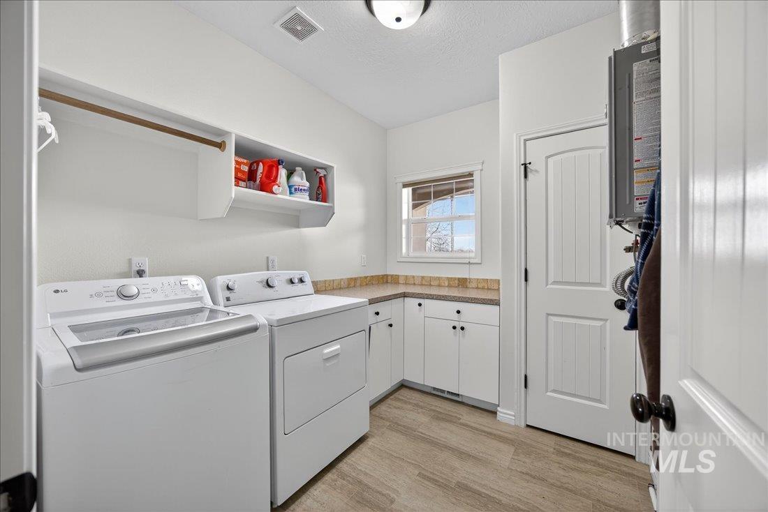 5408 Cassia Road New Plymouth, ID 83655 - Photo 24 of 49 Laundry area featuring light wood-style floors, washing machine and clothes dryer, and a textured ceiling