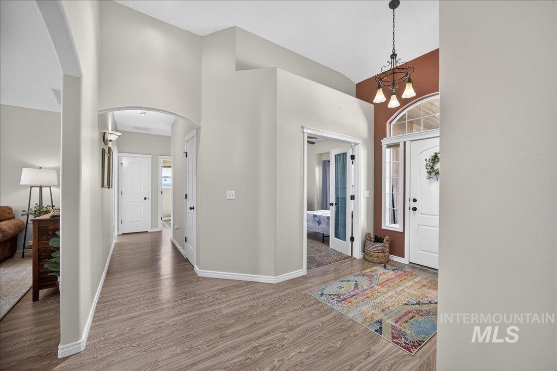 5408 Cassia Road New Plymouth, ID 83655 - Photo 3 of 49 Entrance foyer featuring arched walkways, wood finished floors, suspended lighting, and vaulted ceiling