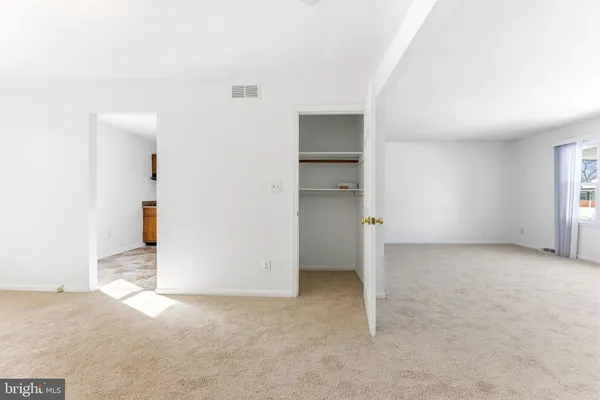 an empty room with closet and windows