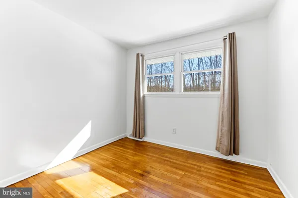 a view of empty room with wooden floor