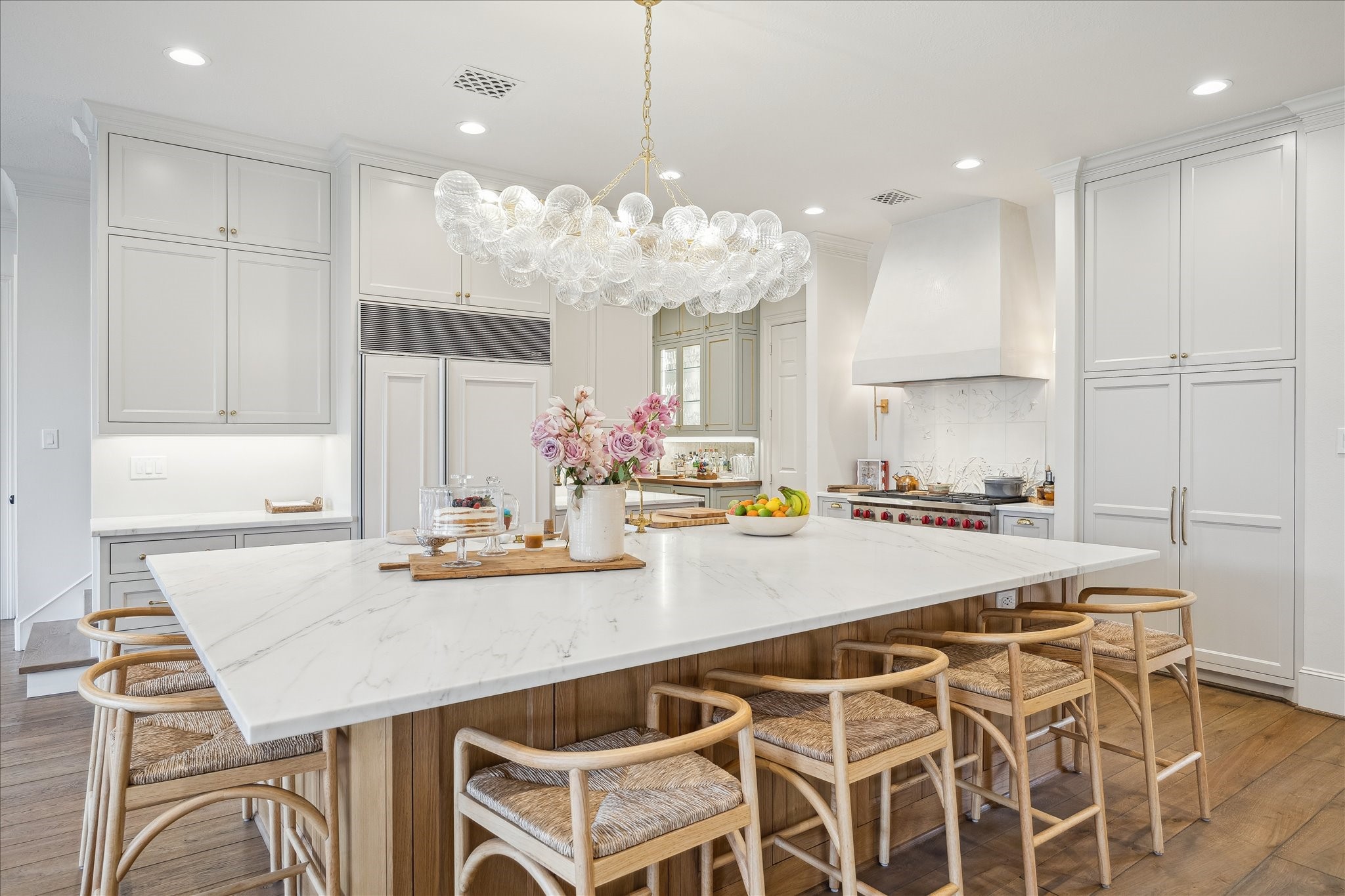 11524 Taylorcrest Road Houston, TX 77024 - Photo 3 of 47 The kitchen, reimagined in 2025, features a white oak island, honed calacatta Lincoln marble countertops, Sub-Zero and Wolf appliances, a custom plaster hood by Segreto, and a custom ceramic mural backsplash.