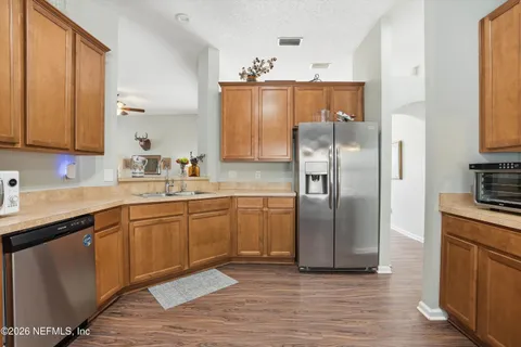 a kitchen with stainless steel appliances granite countertop a refrigerator and a sink
