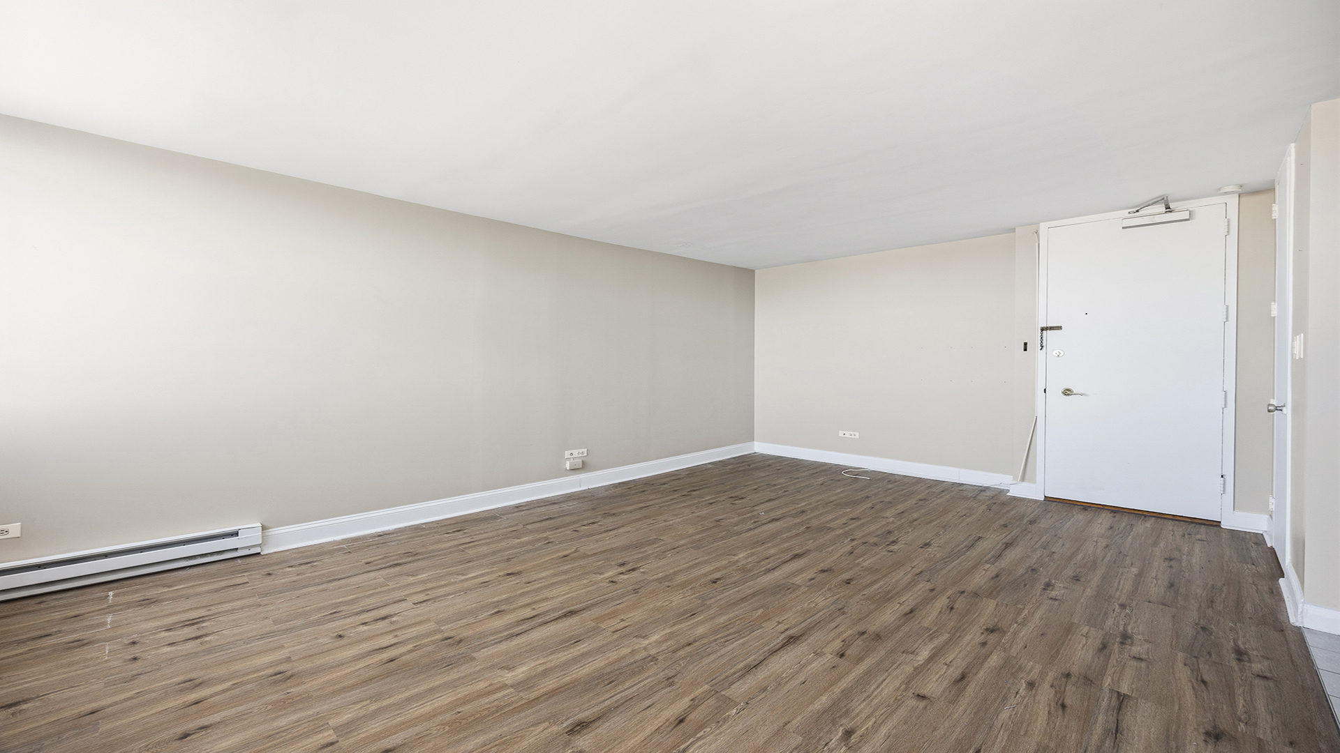3110 North Sheridan Road, Unit 1807 Chicago, IL 60657 - Photo 9 of 21 a view of an empty room with wooden floor and a window
