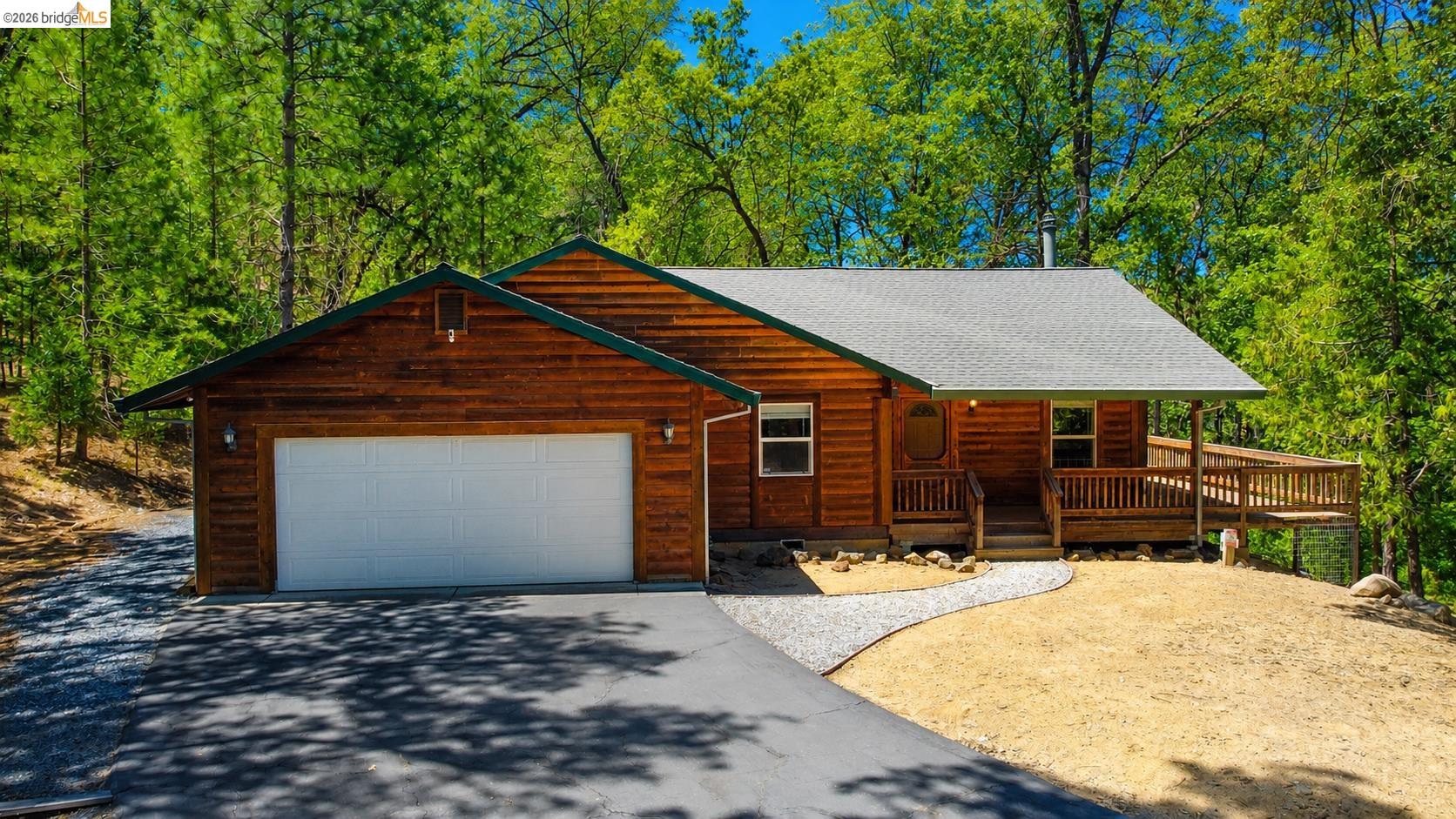 21181 Phoenix Lake Road Sonora, CA 95370 - Photo 1 of 34 Cabin-style residence featuring natural wood siding and a covered front porch