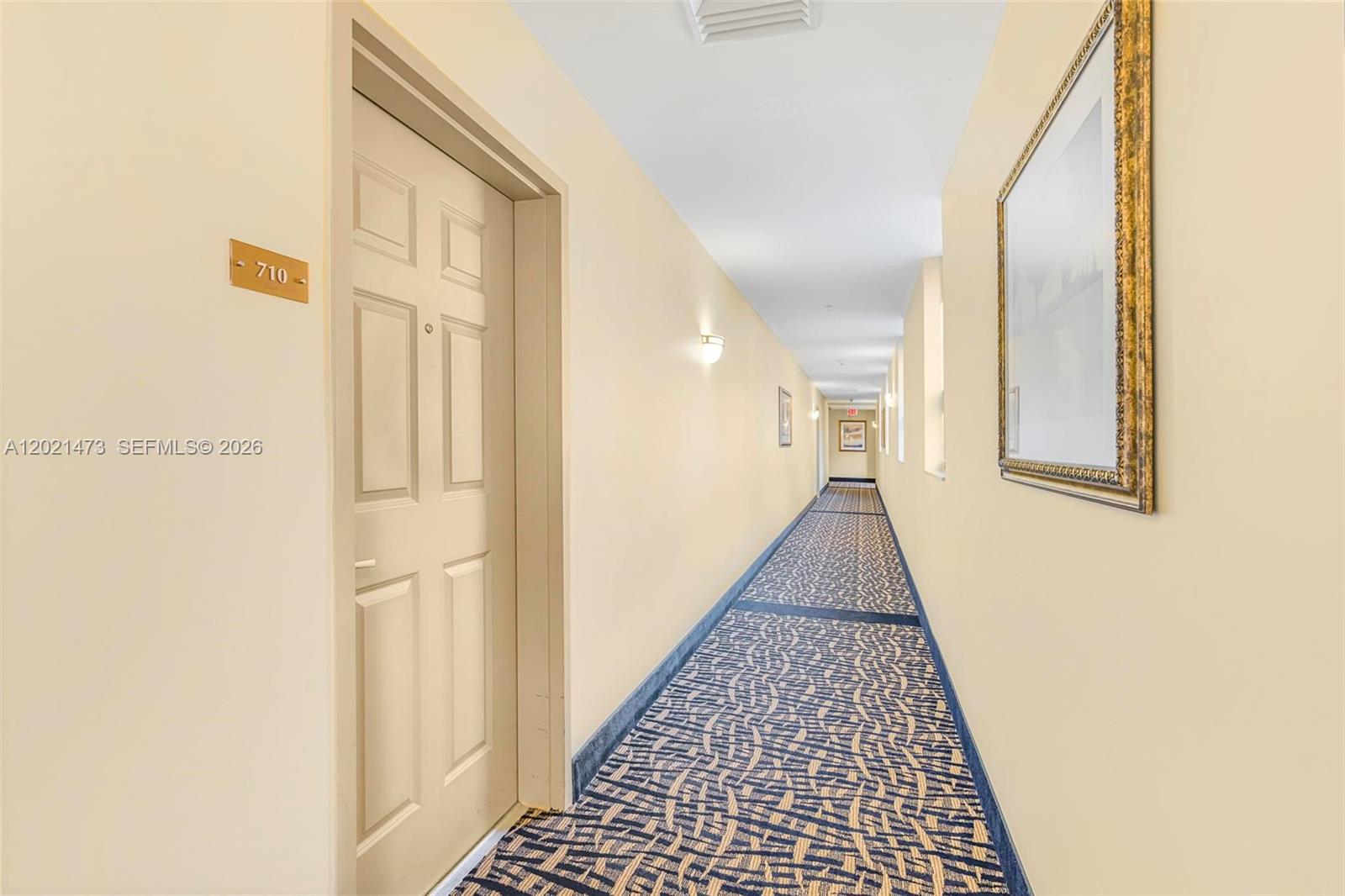 8395 Southwest 73rd Avenue, Unit 710 Miami, FL 33143 - Photo 5 of 32 a view of a hallway with wooden floor and a bathroom