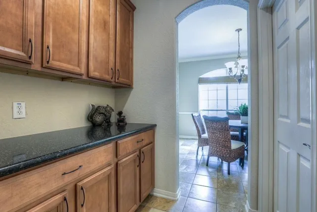 a kitchen with granite countertop white cabinets and stainless steel appliances