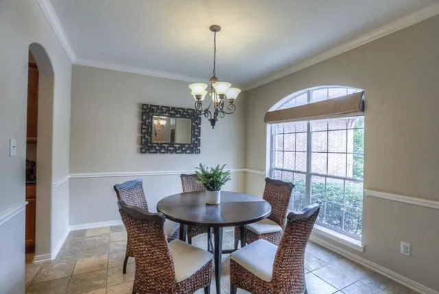 a dining room with furniture a chandelier and a rug