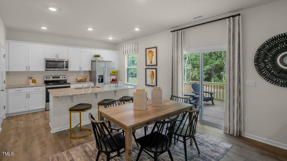 1321 Pavo Path Wendell, NC 27591 - Photo 6 of 30 a dining room with kitchen island a table and chairs