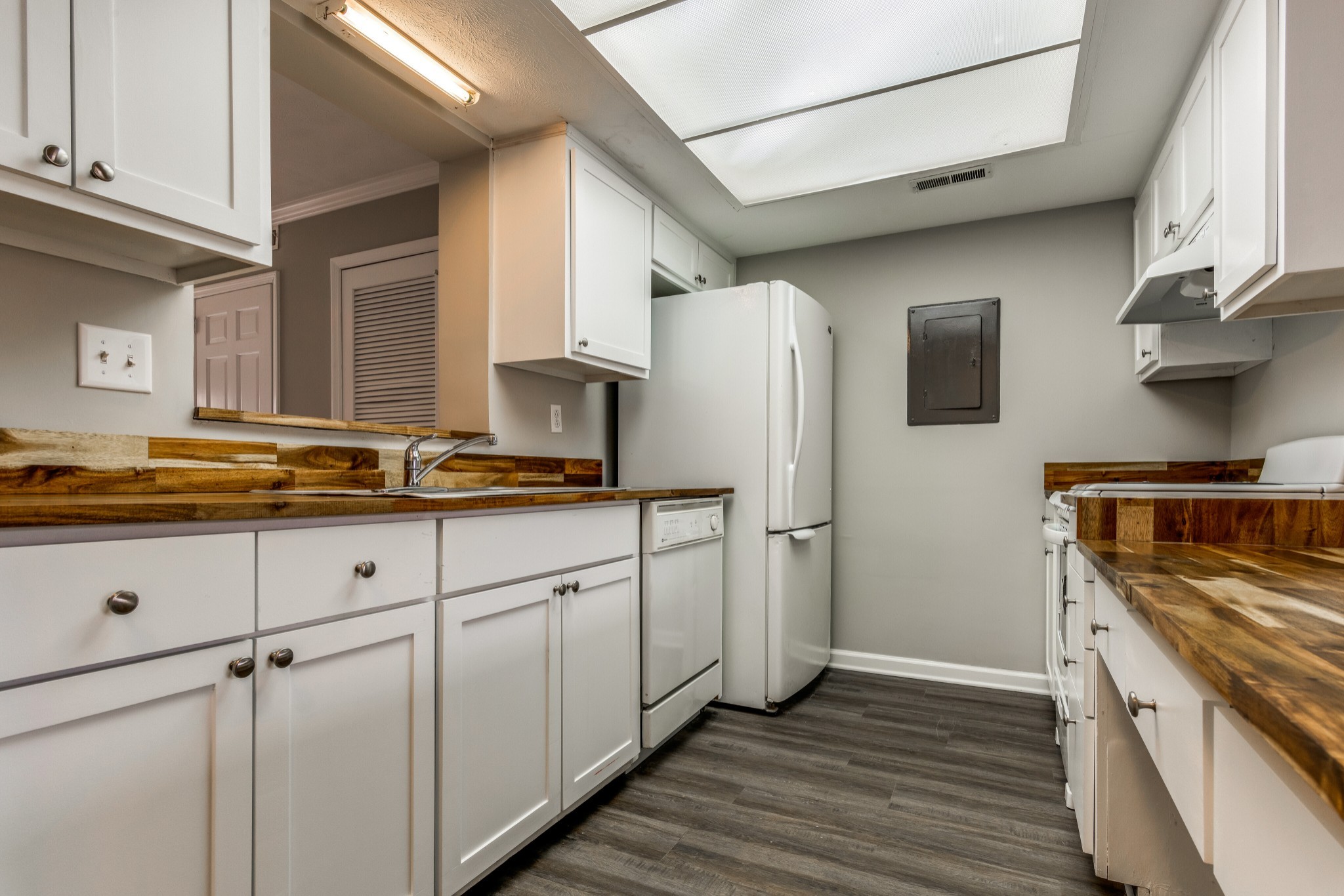 4001 Anderson Road, Unit R105 Nashville, TN 37217 - Photo 4 of 17 a kitchen with stainless steel appliances granite countertop a refrigerator a stove and a sink with wooden floor