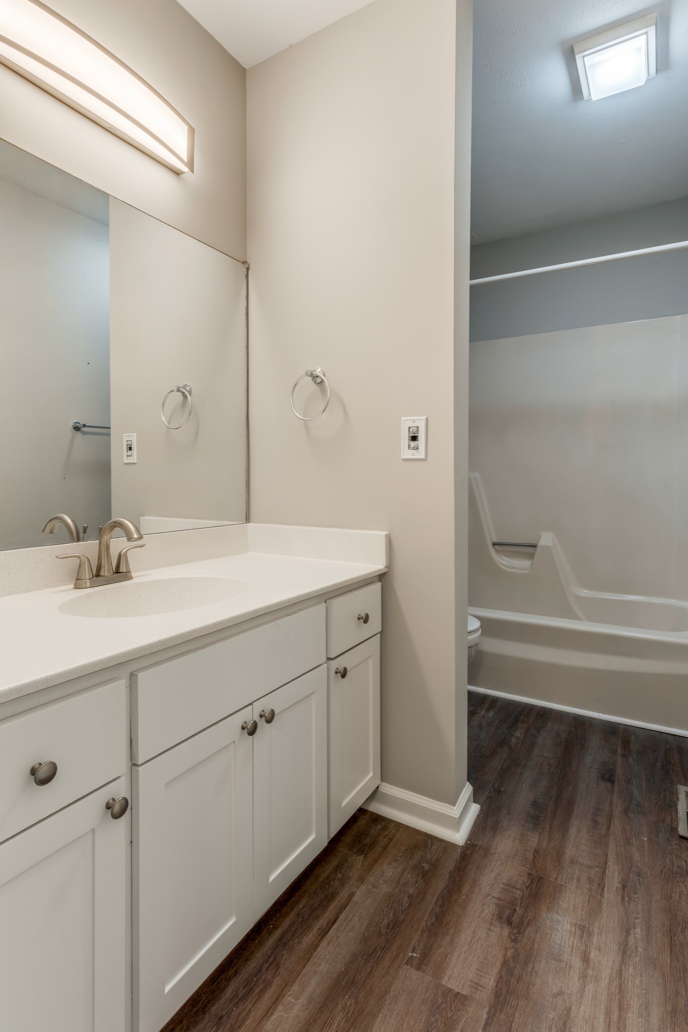 4001 Anderson Road, Unit R105 Nashville, TN 37217 - Photo 10 of 17 a bathroom with a double vanity sink a mirror and a bathtub