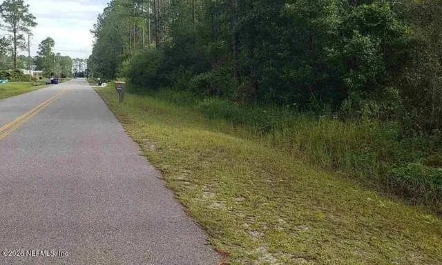 a view of a water pond with green yard