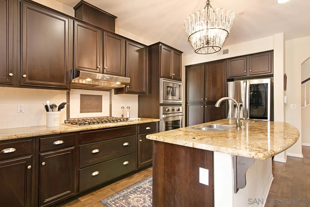 1121 Ocean Ridge Court Oceanside, CA 92056 - Photo 12 of 30 a kitchen with kitchen island granite countertop a sink cabinets and stainless steel appliances