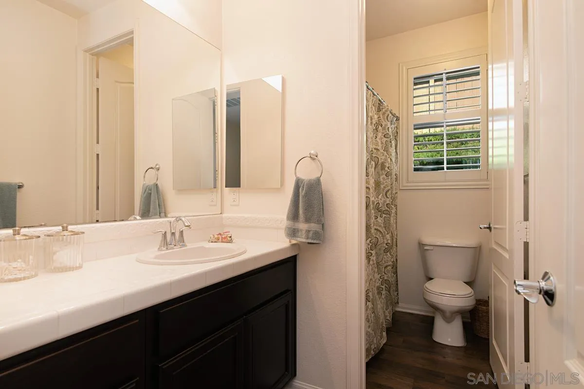 1121 Ocean Ridge Court Oceanside, CA 92056 - Photo 14 of 30 a bathroom with a sink a toilet and a large mirror