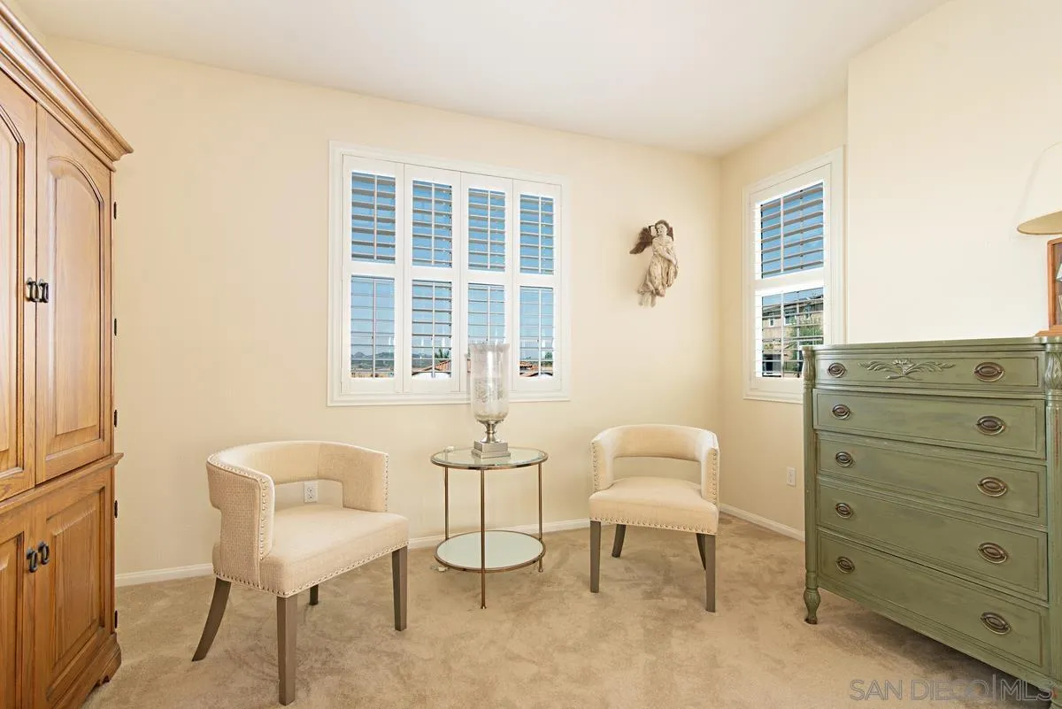 1121 Ocean Ridge Court Oceanside, CA 92056 - Photo 16 of 30 a spacious bedroom with a bed and a chair