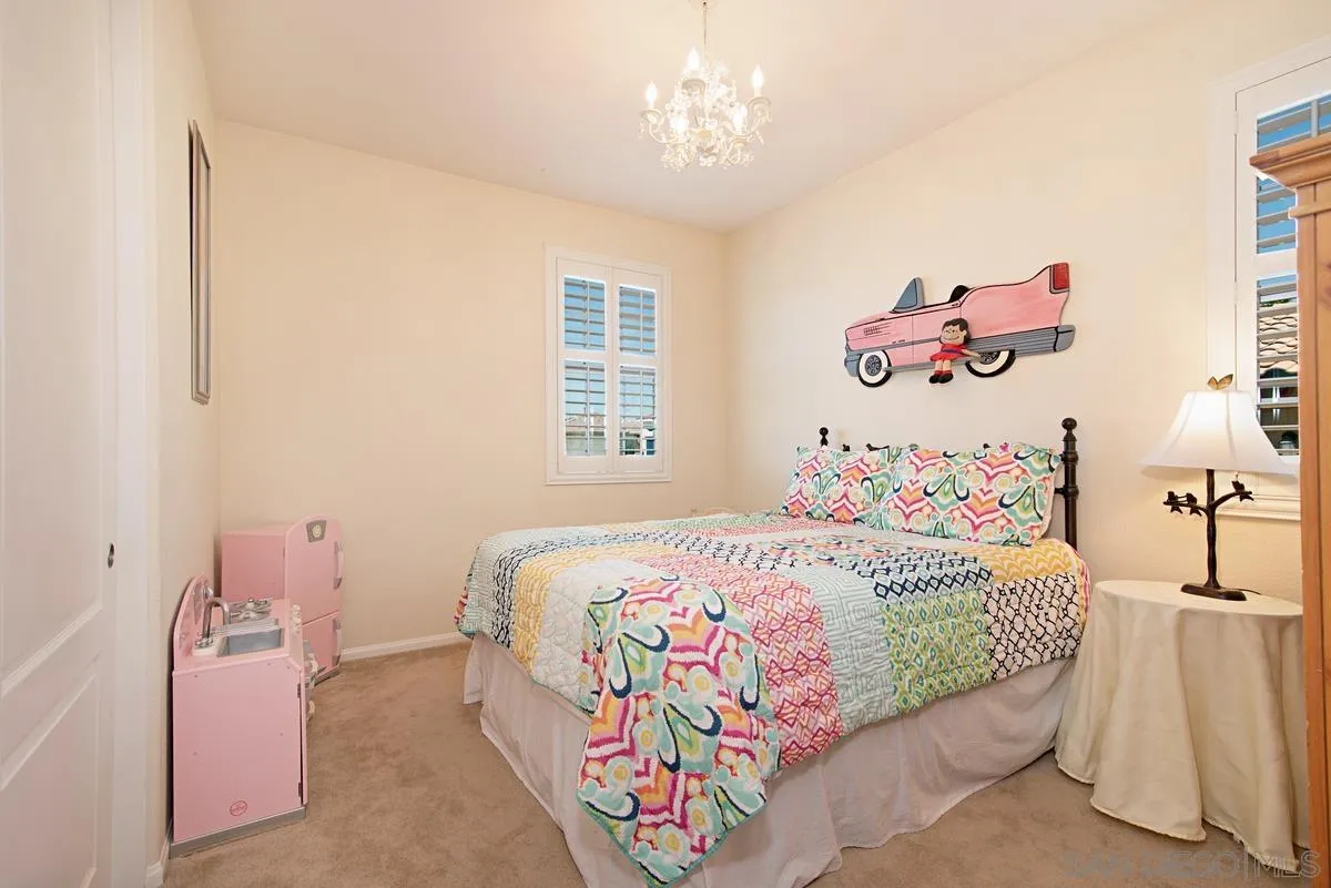 1121 Ocean Ridge Court Oceanside, CA 92056 - Photo 23 of 30 a bedroom with a bed and a chandelier