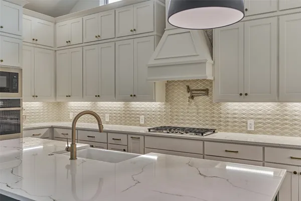 a kitchen with granite countertop a sink a stove and cabinets