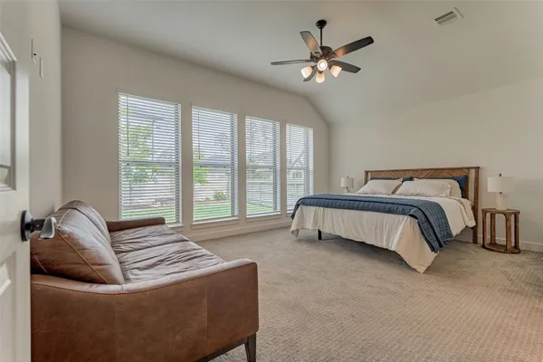 a spacious bedroom with a bed and a chandelier
