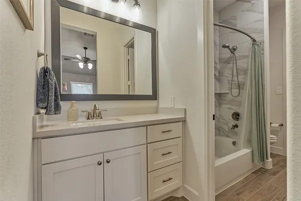 a bathroom with a bathtub a sink a vanity and a mirror