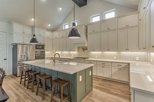 a kitchen with stainless steel appliances granite countertop a sink a stove and a refrigerator