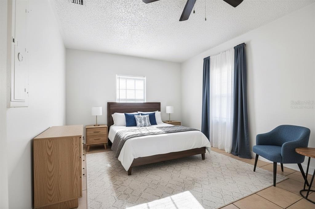 8800 Southeast 89th Place Ocala, FL 34472 - Photo 12 of 18 a bedroom with a bed a chair and potted plant on the dresser