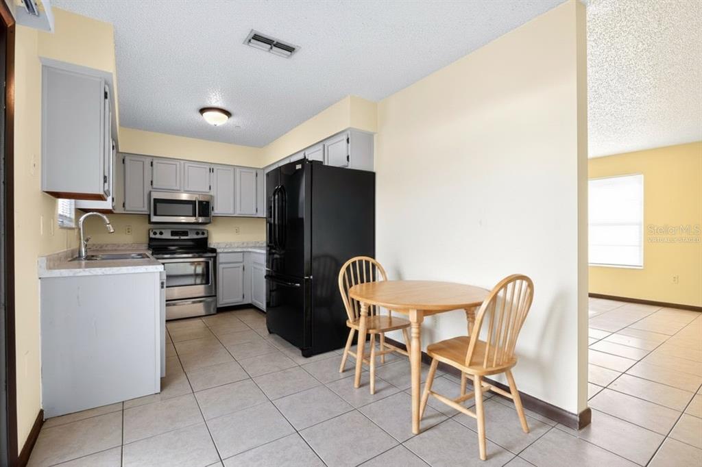8800 Southeast 89th Place Ocala, FL 34472 - Photo 5 of 18 a kitchen with stainless steel appliances a refrigerator stove microwave and cabinets
