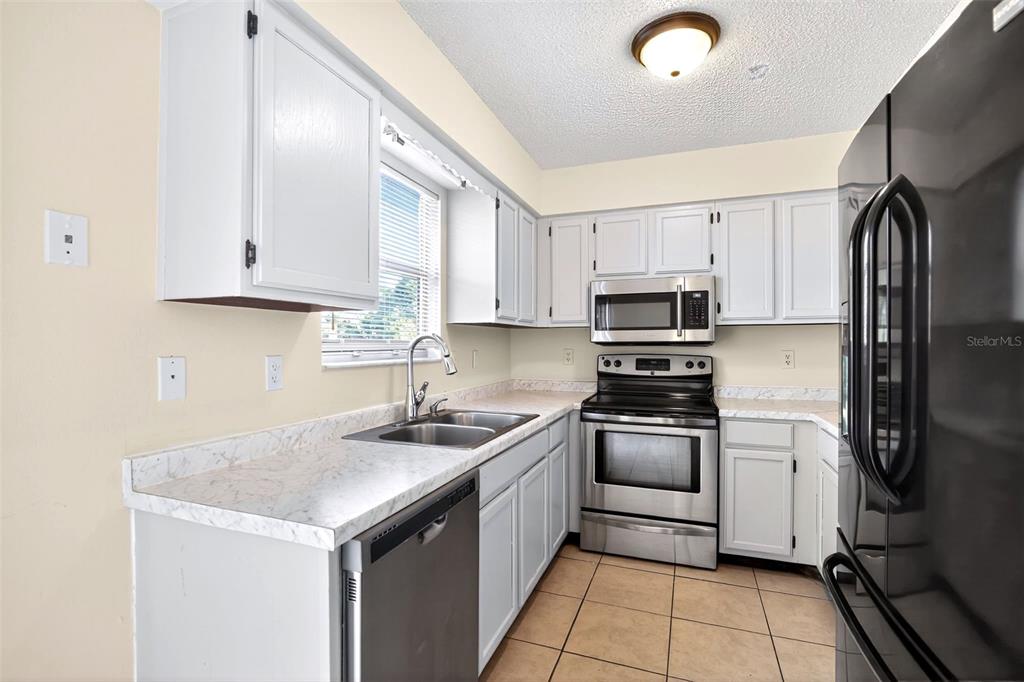 8800 Southeast 89th Place Ocala, FL 34472 - Photo 6 of 18 a kitchen with stainless steel appliances granite countertop a sink stove and refrigerator