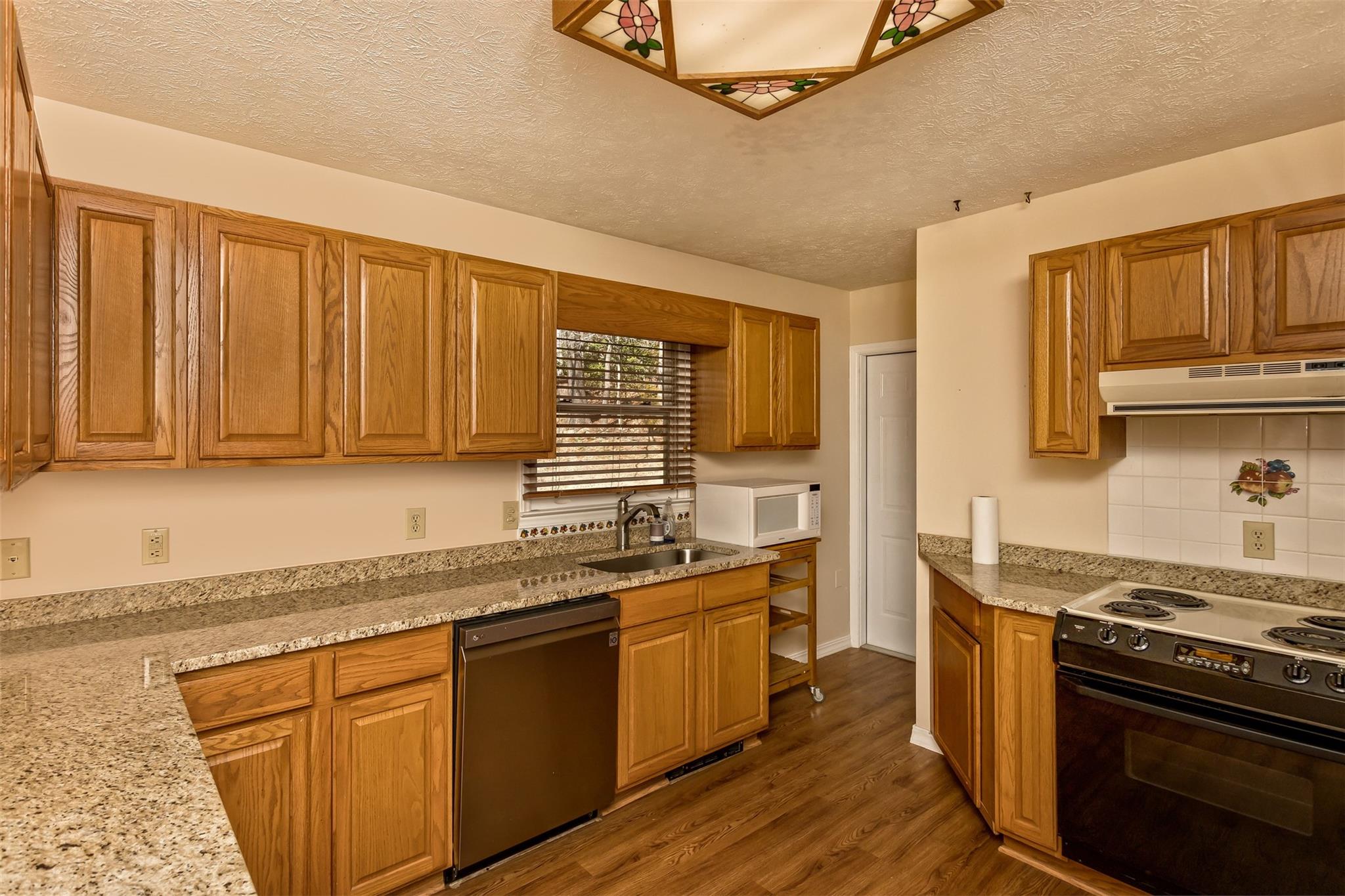 124 Beaverdam Loop Road Candler, NC 28715 - Photo 12 of 25 a kitchen with stainless steel appliances granite countertop a stove a sink dishwasher and a refrigerator