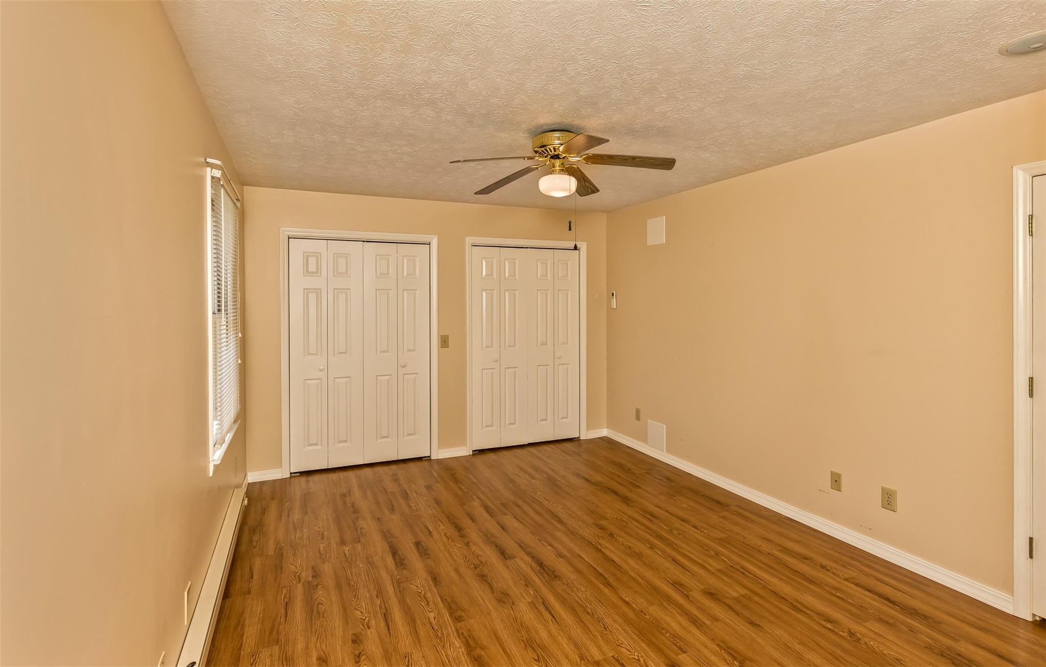 124 Beaverdam Loop Road Candler, NC 28715 - Photo 16 of 25 a view of a room with wooden floor and ceiling fan