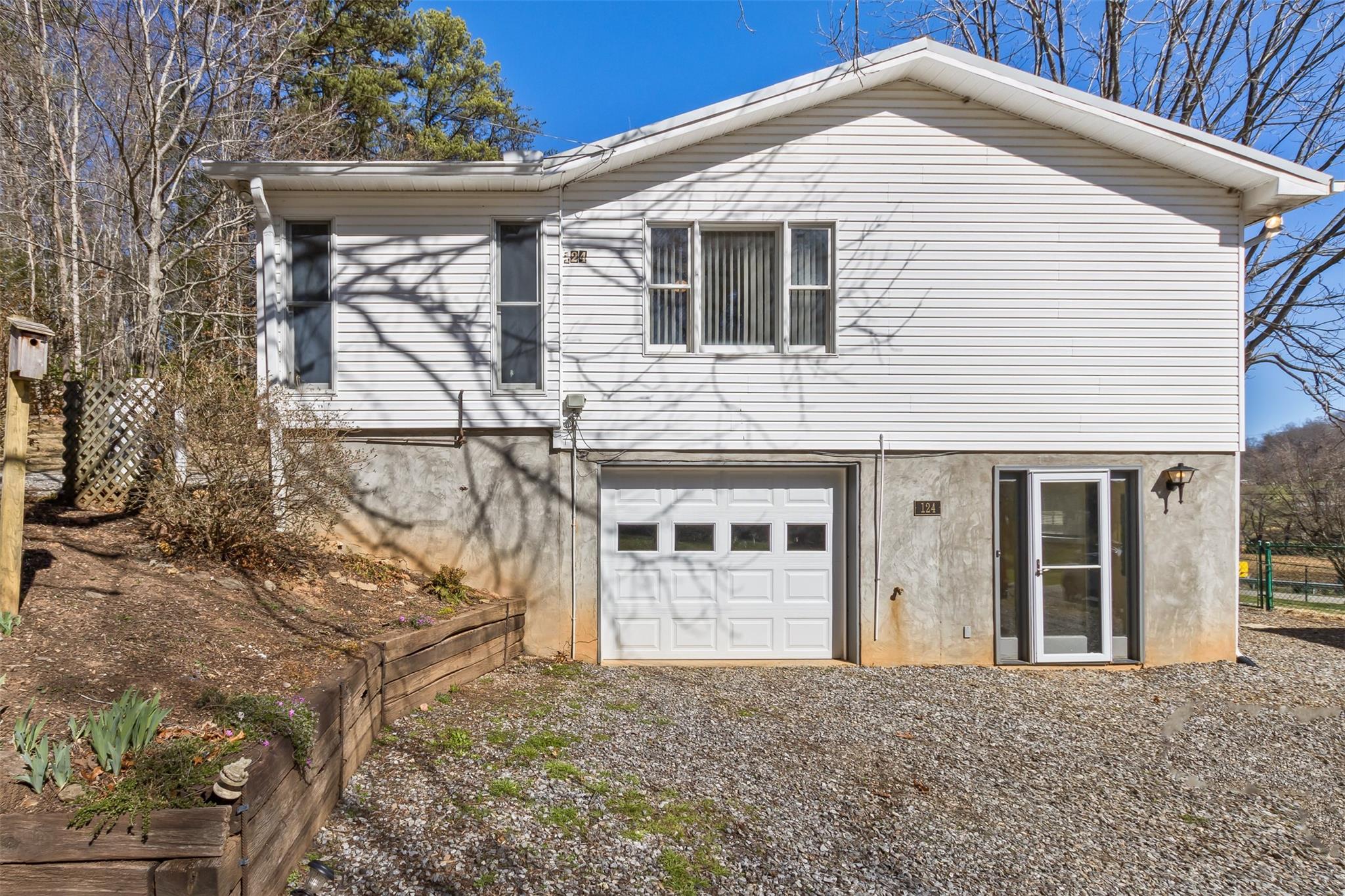 124 Beaverdam Loop Road Candler, NC 28715 - Photo 3 of 25 a view of a white house with large windows and a small yard