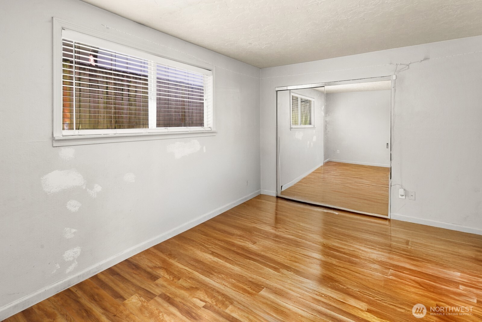 101 Southwest 119th Street, Unit 102 Burien, WA 98146 - Photo 14 of 15 a view of an empty room with wooden floor and a window