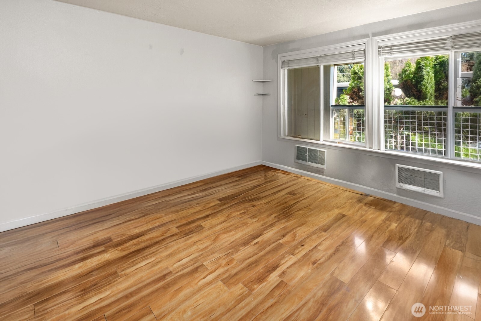 101 Southwest 119th Street, Unit 102 Burien, WA 98146 - Photo 5 of 15 a view of an empty room with wooden floor and a window