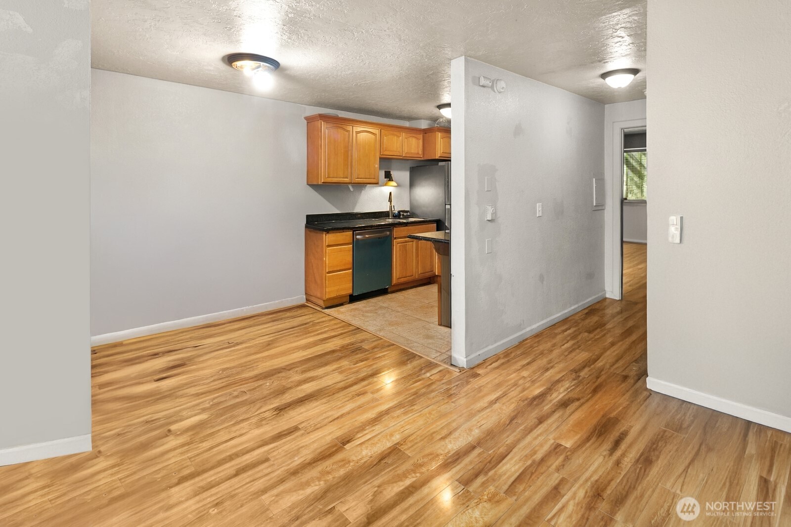101 Southwest 119th Street, Unit 102 Burien, WA 98146 - Photo 7 of 15 a kitchen with granite countertop a refrigerator and a stove top oven