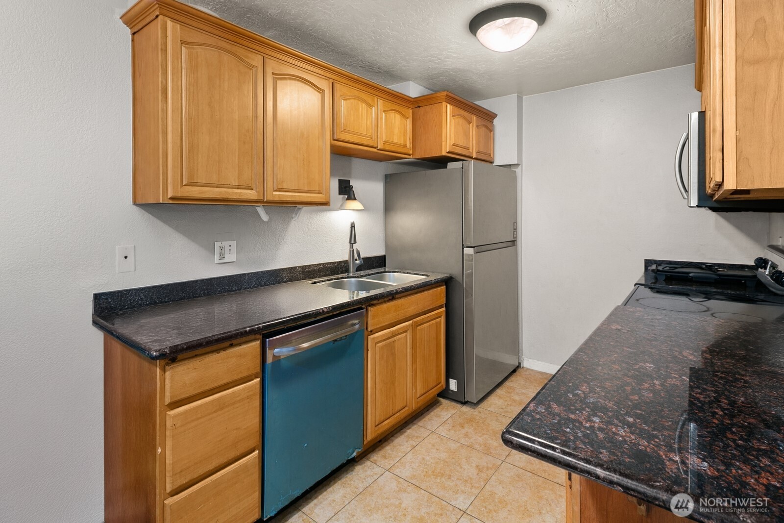 101 Southwest 119th Street, Unit 102 Burien, WA 98146 - Photo 10 of 15 a kitchen with stainless steel appliances granite countertop a sink stove and refrigerator