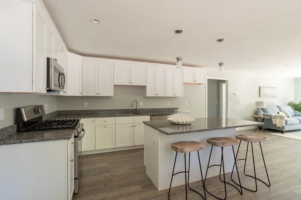 11 Indian Neck Road Wareham, MA 02571 - Photo 21 of 41 a kitchen with stainless steel appliances granite countertop a stove a sink and white cabinets